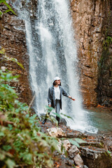 Obraz premium young pretty woman hiking enjoying view of waterfall