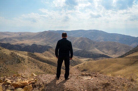 Rear View Of Man Standing And Enjoying To Expansive Views On Caucasus Mountains While Hiking. Travel Concept.