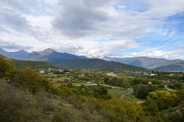 Panoramic view from the height of the hill to the Gremi village in Alazani valley and Caucasian Mountains in the distance. Georgia