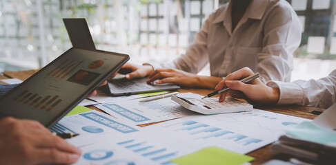 Financial analyst analysis business financial report on digital tablet during discussion at meeting of corporate showing the results of their successful teamwork, business meeting concept, Marketing