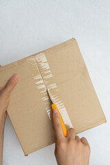 Unboxing the courier box with a cutter knife