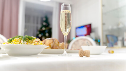 a glass of champagne and a cork on a festive New Year's table