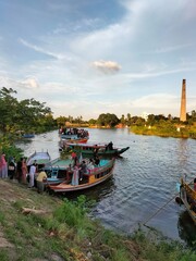 Fototapeta na wymiar Brick kiln factory riverside. People on the boat in river.