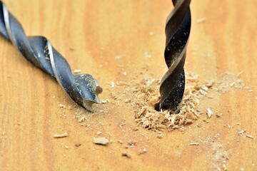 Detalle de una broca abriendo un agujero en una tabla de madera