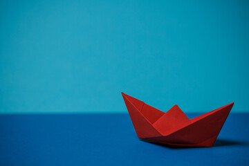 red paper boat on blue water