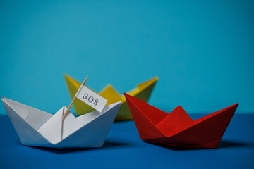sos paper boat on blue background