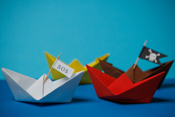 sos pirate paper boat on blue background