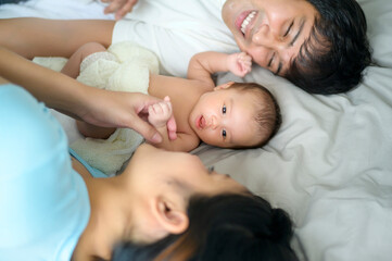 Smiling young mother and father with a new born baby, family and love concept