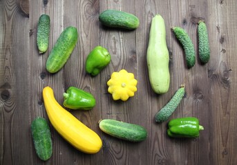 Yellow, green squash vegetables, cucumbers, fresh paprika from garden on wooden background
