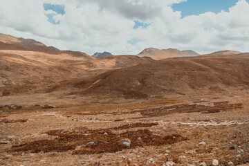 dry and desolate mountain terrain landscape in Deosai National Park on sunny day in Pakistan