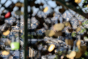 View of Paris from Montmartre hill, through the fence where tourists hang padlocks