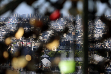 View of Paris from Montmartre hill, through the fence where tourists hang padlocks