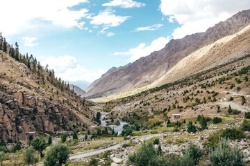 Fototapeta na wymiar wide landscape of a river flowing through the mountains of Astore Valley in Pakistan on a sunny summer day