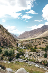 natural river flowing through a rocky mountain ravine in Astore Valley Pakistan on sunny summer day