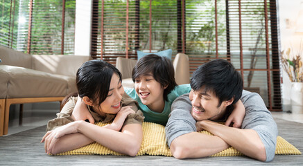 portrait of happy Asian family spending time together on sofa in living room. family and home...