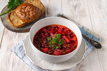 vegetable vegetarian soup and loaves of bread with seeds on a white wooden background