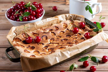 Sponge cake with cherries on a table, selective focus. Homemade cake