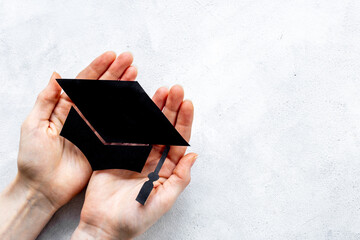 Students hands with graduation hat or academic cap paper cut
