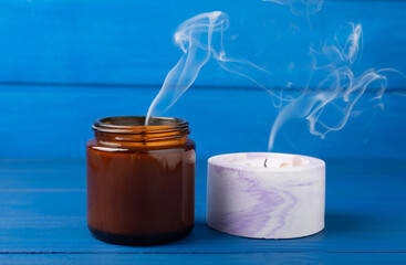 Smoldering candle wick and smoke on blue wood texture. winter home decor. Soy ecological candle....