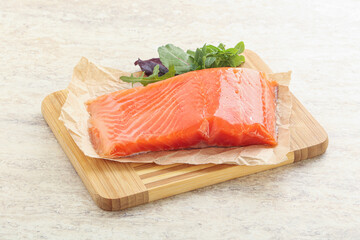Raw salmon fillet over board