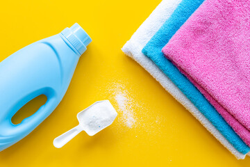 White washing powder with towels and a laundry conditioner bottle