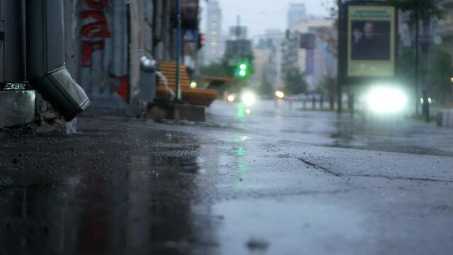Filming of seething streams of water flowing from drainpipes in a metropolis.