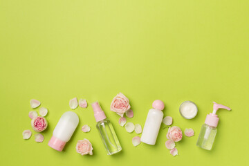 Set of small cosmetic bottles on color background, top view
