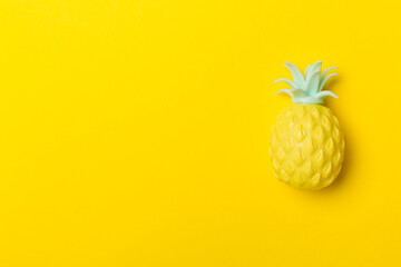 Pineapple fruit toy on color background, top view