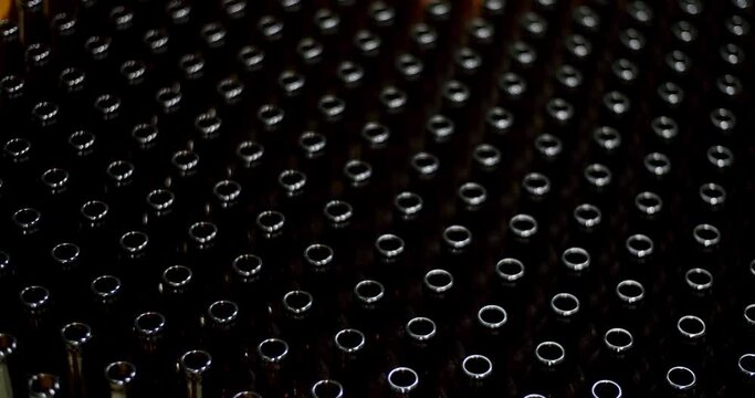 Close-up of brown bottles in a factory. A long row of glass bottles. Top view of a production line. Factory concept. Factory brewery concept.