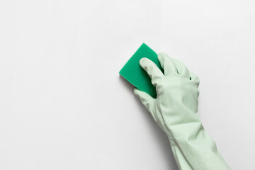 hand in a rubber glove with a sponge on a white background, cleaning and cleanliness concept, space for text