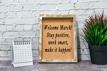 Inspirational and motivational quote on wooden frame and March 2022 calendar.
