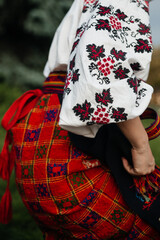 Part of Ukrainian traditional national costume closeup: embroidered shirt, vyshyvanka, skirt, woven belt. Culture of Ukraine