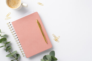 Business concept. Top view photo of workplace pink diary gold pen cup of hot drinking clips and...