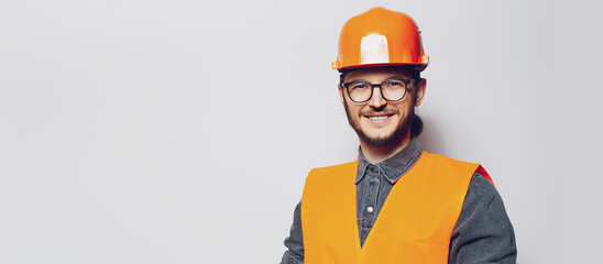 Portrait of young construction worker on white. Panoramic banner, copy space.