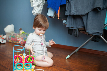 baby girl playing with toys in children's room