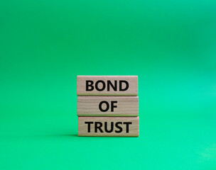 Bond of trust symbol. Wooden blocks with words Bond of trust. Beautiful green background. Business and Bond of trust concept. Copy space.