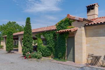 Traditional italian style house with tile roof in a sunny summer day. Ivy green living wall on the building. Residential architecture theme.