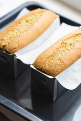 Two baked buns in cake pans.