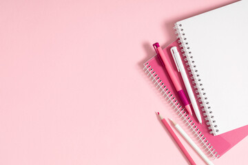 Back to school. Creative minimalist school or office supplies, notebook, pen on pink background. Education concept. Flat lay, top view, copy space