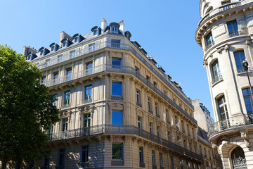 The facades of traditional French houses with typical balconies and windows. Paris.