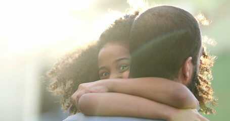 Cute little girl hugging father. Mixed race kid embraces dad outside in sunlight