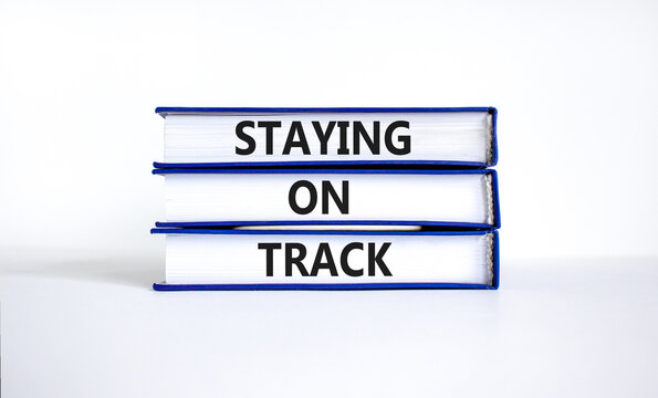 Staying on track symbol. Concept words Staying on track on books on a beautiful white table white background. Business, motivational and staying on track concept. Copy space.