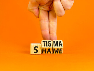Stigma or shame symbol. Concept words Stigma or Shame on wooden cubes. Businessman hand. Beautiful orange table orange background. Business stigma or shame concept. Copy space.