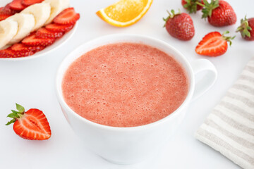 Red smoothie made of strawberry and fruits. Summer detox cocktail with berries and banana. Sweet healthy drink for raw diet.