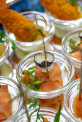 salmon rolls with olive and caviar in a glass container