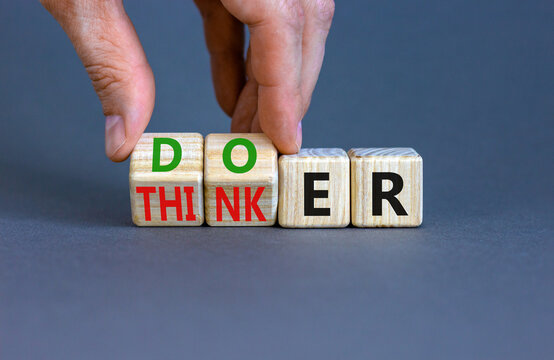 Doer or thinker symbol. Concept words Doer or thinker on wooden cubes. Businessman hand. Beautiful grey table grey background. Business and doer or thinker concept. Copy space.