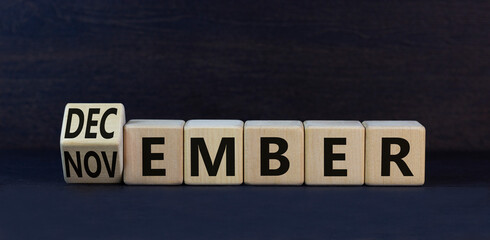 Symbol for the change from November to December, winter. Turned wooden cubes and changed the concept word November to December. Beautiful black background. Happy December concept. Copy space.