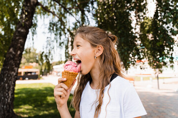 Funny child girl eating ice cream cone in waffle cup. Creative advert for ice cream stand and shop.