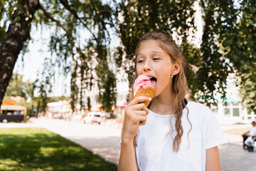 Funny child girl eating ice cream cone in waffle cup. Creative advert for ice cream stand and shop.