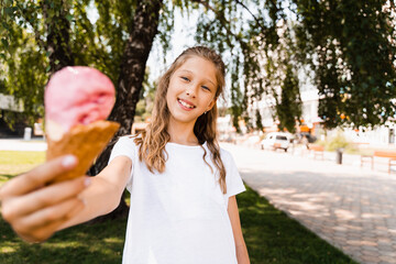 Funny child girl with ice cream cone in waffle cup. Summer sweets food. Creative advert for ice...